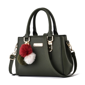 Olive green pebbled leather handbag with gold hardware and a tricolor plush pompom charm