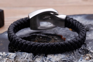 Macro shot of men's black braided leather bracelet with stainless steel magnetic clasp