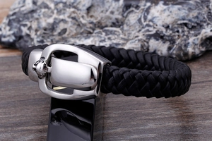 Detailed close-up of a silver leopard head buckle on black braided leather bracelet