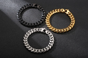 Detailed close-up of Cuban link bracelets in gold, black, and silver stainless steel finishes