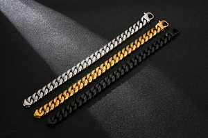 Detail of silver, gold, and black Cuban link bracelets with secure lobster clasps