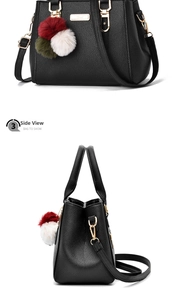 Macro detail of black pebble leather handbag with gold hardware and plush charm pendant