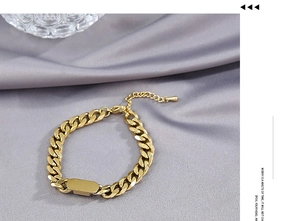 Detail of a polished gold Cuban link ID chain necklace with an adjustable water drop charm