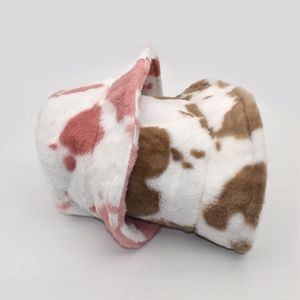 Detailed view of pink and brown cow print plush bucket hats showing soft furry texture