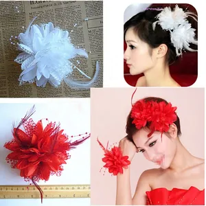 Detail of handmade feather mesh headpiece with organza flowers and faux pearls