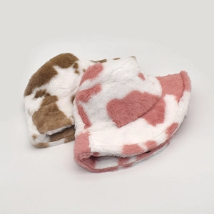 Detail of plush cow print bucket hats in brown and pink showing soft fuzzy texture