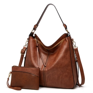 Detailed shot of brown leather tote bag with matching zippered coin purse and strap