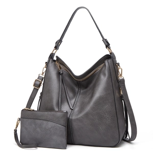 Detail of dark gray faux leather tote set with gold hardware and tassel accents