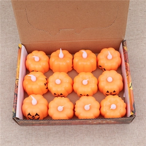 Set of 12 small orange LED pumpkin candle lights for Halloween party decor in a box