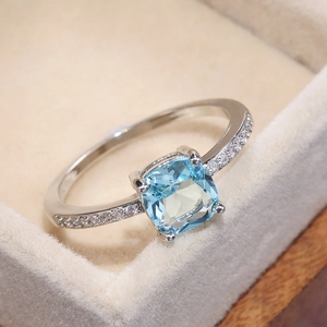 Macro detail of cushion-cut blue sapphire ring with pavé diamonds in jewelry box