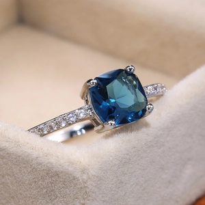 Macro shot of a square blue sapphire ring with micro-pave diamonds on silver band