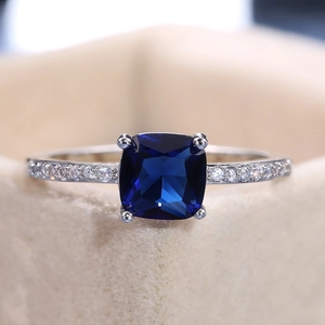 Macro shot of cushion-cut blue zircon stone with shimmering silver pavé-set band