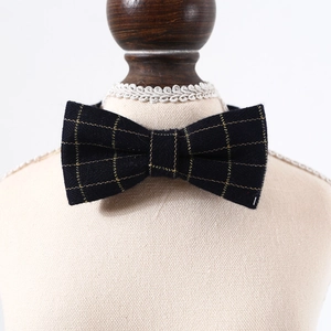 Detail of navy blue bow tie with gold plaid texture on a vintage mannequin display
