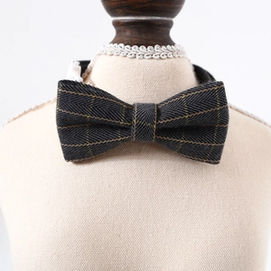 Detailed macro view of dark gray herringbone tweed pet bowtie collar with gold stripe accents