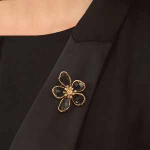 Vintage black crystal flower brooch with gold edges and zirconia center on black blazer