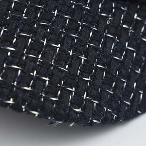Macro shot of black tweed fabric with metallic silver threads in a classic plaid pattern