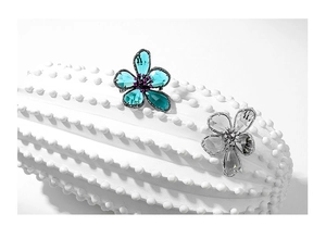 Detail shot of vintage crystal flower brooches with blue and clear faceted petals