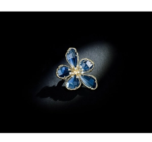 Macro shot of dark blue crystal flower petals with gold trim and zircon center