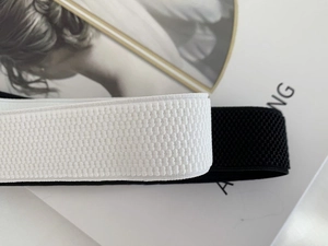 Detailed close-up showing the elastic texture of black and white stretch waist belts
