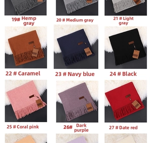 Detail view of colorful cashmere-feel scarves with fringed edges and leather patches