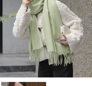 Detail of soft pale green cashmere scarf with fringe and white quilted chain bag