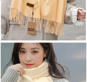 Detailed shot of cream cashmere scarf showing soft fringe texture and fabric quality