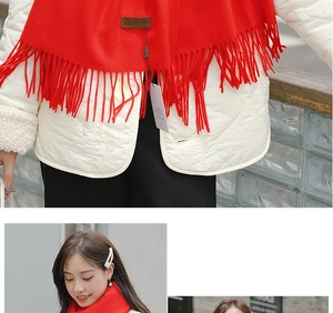 Detailed macro view of soft red scarf texture featuring fringe design and leather brand tag