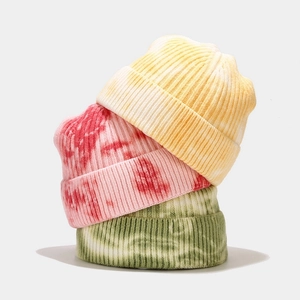 Detailed close-up showing the ribbed texture and tie-dye patterns of three knit beanies