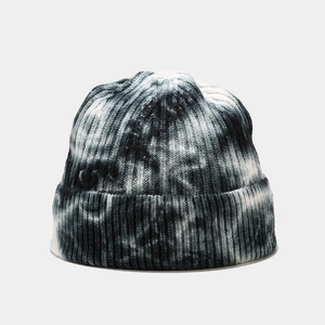 Close-up showing the intricate black and white tie-dye knit texture on the warm beanie hat