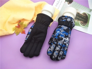 Detail of kids winter ski gloves with camouflage patterns and adjustable wrist straps