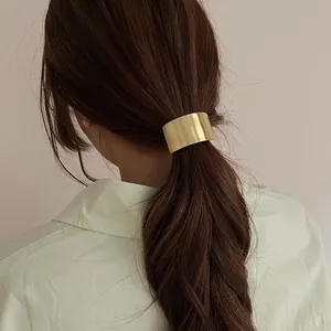 Detail of brushed gold metal hair cuff for ponytail on minimalist elastic hair tie