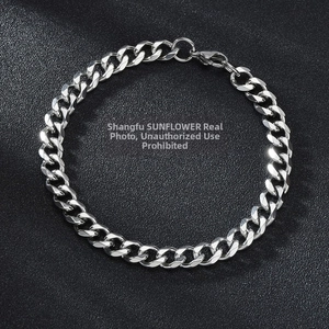 Close-up of polished silver Cuban link chain bracelet with a classic lobster clasp