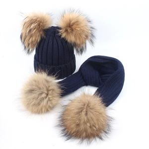 Navy blue knitted winter set with two large faux fur pom-poms on the hat and scarf