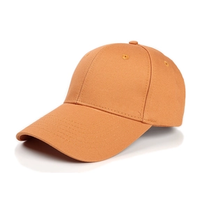 Detail of an orange cotton baseball cap showing reinforced eyelets and six-panel stitching