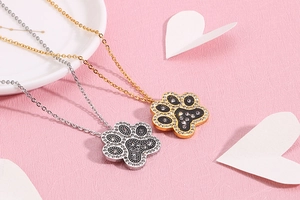 Detailed view of paw print necklaces in gold and silver finish with sparkling rhinestones