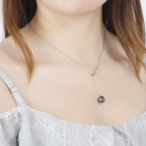 Silver Y-necklace featuring a dark pearl pendant elegantly worn by a model