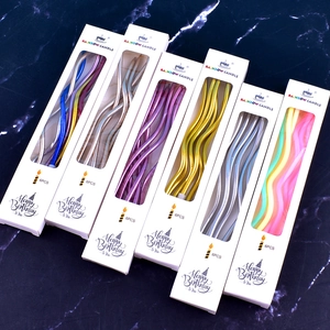Detailed view of spiral wave birthday candles in metallic colors on marble background