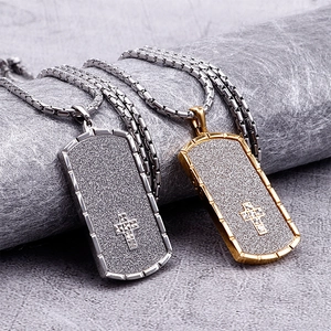 Close-up of gold and silver rectangular military cross pendants on snake chains