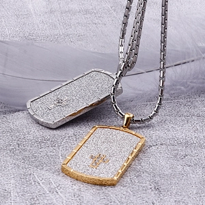 Detail of gold and silver rectangle necklaces with frosted finish and cross cut-out