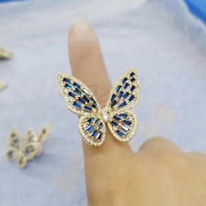 Macro detail of butterfly ring with blue crystals and sparkling diamonds on a golden band