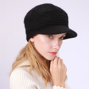 Detailaufnahme der schwarzen Strickmütze mit Schirm und grober Wolltextur für Damen