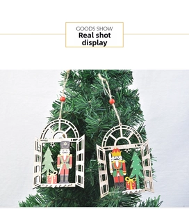 Detail of wooden Christmas window ornaments with nutcracker and tree motifs on a branch