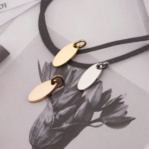 Ovale Edelstahl-Anhänger in Gold, Roségold und Silber auf einer dekorativen Karte