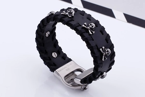 Detail of black braided leather bracelet with silver skull studs and 316L steel clasp