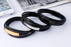 Close-up of woven leather men's bracelets with gold, silver, and black steel accents