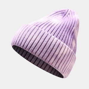 Detailed macro view of the purple tie-dye knit beanie showing ribbed texture and stitching