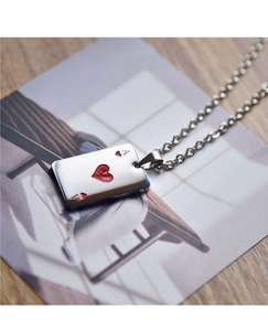 Macro shot of silver poker Ace of Hearts pendant with red enamel on a steel chain