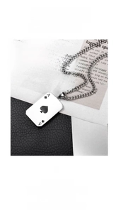 Detailed close-up of Ace of Spades poker pendant in silver steel on dark leather background