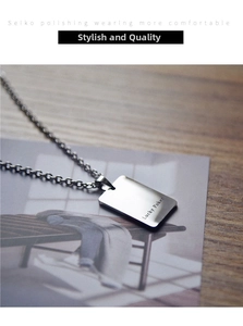 Detail view of a silver stainless steel Lucky Poker pendant on a magazine and wooden desk
