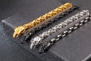 Macro shot of punk skull bracelets in gold, silver, and black finish with Byzantine chain link
